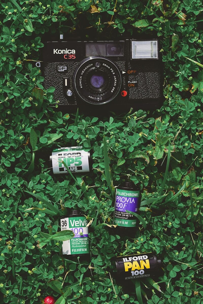 Vintage konica c35 camera and film rolls on green clover.